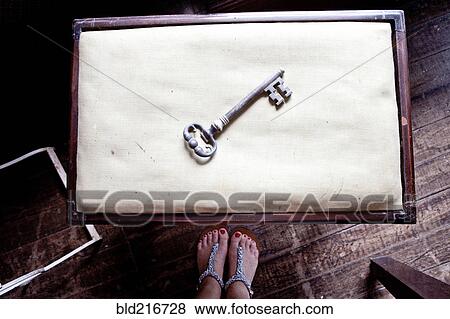 Woman standing near skeleton key on table View Large Photo Image Stock Photo - Woman standing near skeleton key on table. Fotosearch