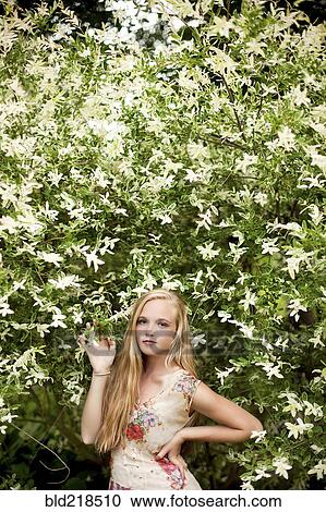 Stock Image - Woman standing under flowering tree. Fotosearch
