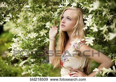 Stock Photo - Woman standing under flowering tree. Fotosearch