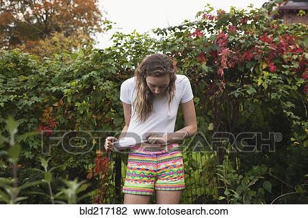 Woman stretching her shirt in shrub bushes View Large Photo Image Stock Image - Woman stretching her shirt in shrub bushes. Fotosearch