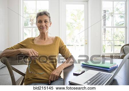 Stock Photography - Woman using laptop in living room. Fotosearch