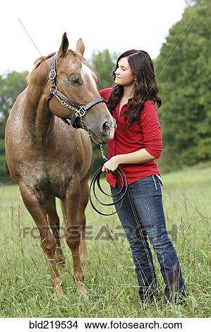 Picture - Woman walking horse in rural field. Fotosearch