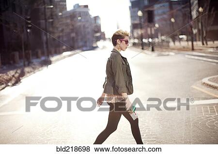 Stock Photo - Woman walking in city intersection. Fotosearch
