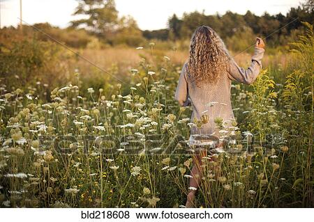 Woman walking in rural field View Large Photo Image Stock Photo - Woman walking in rural field. Fotosearch