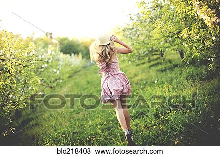 Woman walking in rural orchard View Large Photo Image Stock Photo - Woman walking in rural orchard. Fotosearch