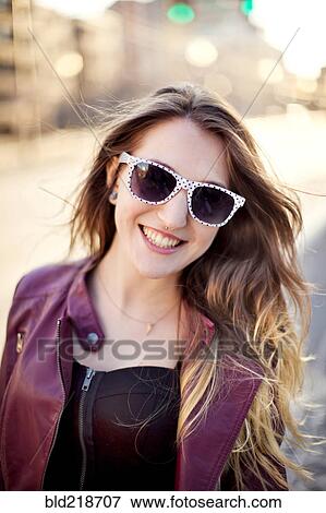 Stock Photo - Woman wearing sunglasses in city. Fotosearch