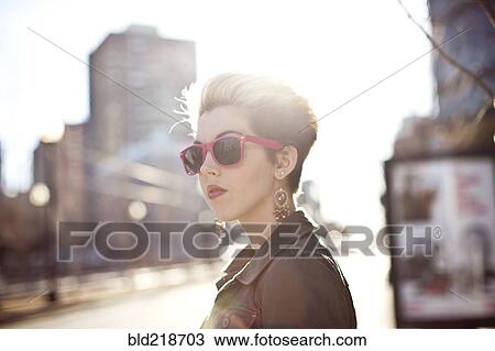 Woman wearing sunglasses on city sidewalk View Large Photo Image Stock Image - Woman wearing sunglasses on city sidewalk. Fotosearch