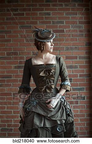 Stock Image - Woman wearing vintage gown and hat. Fotosearch