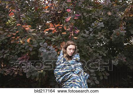 Woman wrapped in blanket near tree View Large Photo Image Picture - Woman wrapped in blanket near tree. Fotosearch