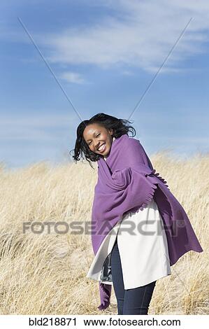 Woman wrapped in shawl on beach View Large Photo Image Stock Image - Woman wrapped in shawl on beach. Fotosearch