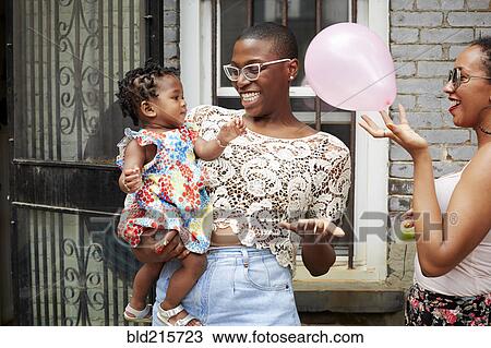Stock Image - Women and girl playing with balloon outdoors. Fotosearch
