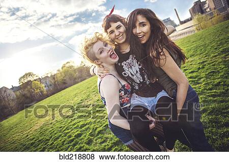 Women carrying friend in urban park View Large Photo Image Stock Photo - Women carrying friend in urban park. Fotosearch