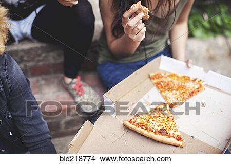 Women eating pizza on front steps View Large Photo Image Picture - Women eating pizza on front steps. Fotosearch
