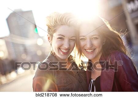 Women hugging on sunny city sidewalk View Large Photo Image Stock Photo - Women hugging on sunny city sidewalk. Fotosearch