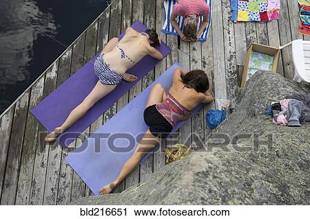 Women practicing yoga on wooden dock View Large Photo Image Stock Image - Women practicing yoga on wooden dock. Fotosearch