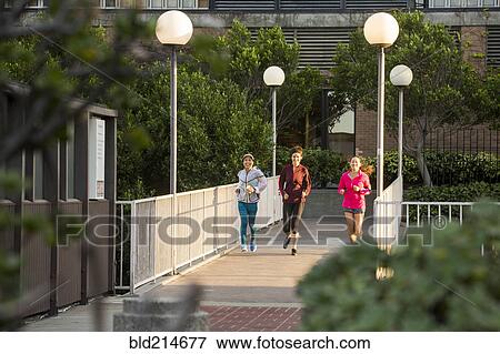 Women running on urban footbridge View Large Photo Image Stock Photo - Women running on urban footbridge. Fotosearch