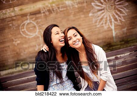 Women sitting on urban bench near graffiti wall View Large Photo Image Stock Image - Women sitting on urban bench near graffiti wall. Fotosearch