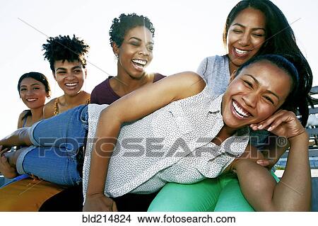 Picture - Women smiling on urban rooftop. Fotosearch