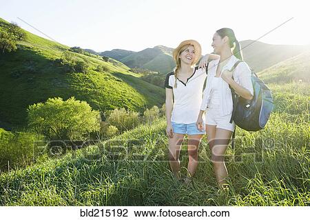 Women talking on grassy hillside View Large Photo Image Stock Image - Women talking on grassy hillside. Fotosearch