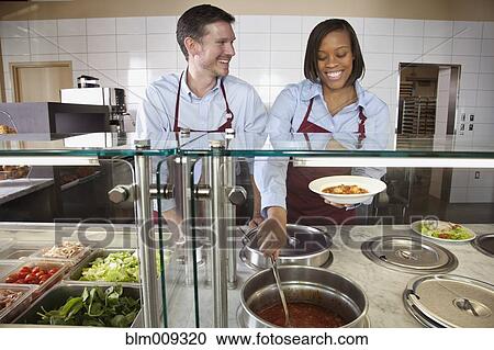 Stock Image - Workers preparing food in cafe. Fotosearch