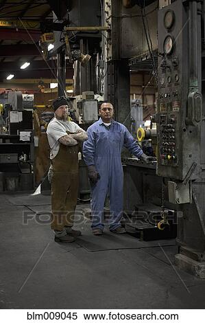Workers standing in factory View Large Photo Image Stock Photography - Workers standing in factory. Fotosearch