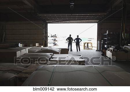Stock Image - Workers standing on loading dock of factory. Fotosearch