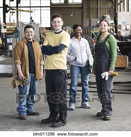Stock Photograph - Workers standing together in factory. Fotosearch