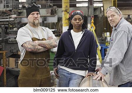 Stock Photography - Workers standing together in factory. Fotosearch