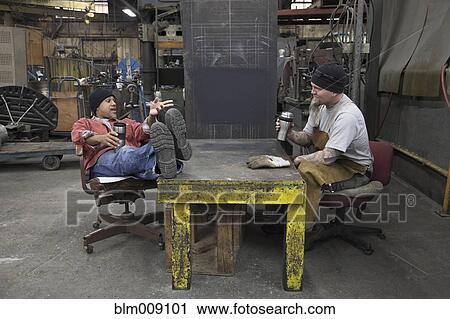 Stock Image - Workers taking break in factory. Fotosearch