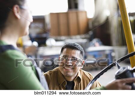 Picture - Workers talking together in warehouse. Fotosearch