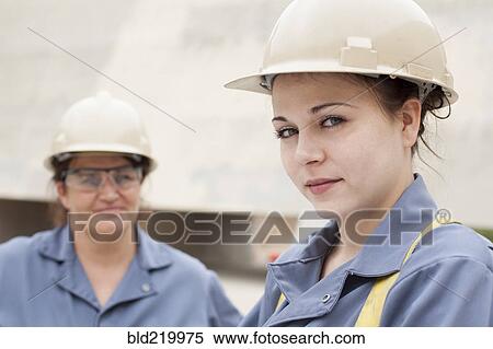 Stock Photography - Workers wearing hard-hats and uniforms at work. Fotosearch