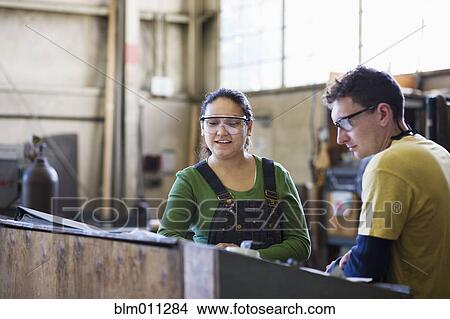 Picture - Workers working together in factory. Fotosearch