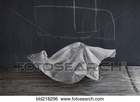 Stock Photograph - Wrinkled napkin floating near chalkboard. Fotosearch