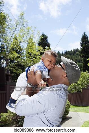African American father lifting and kissing baby son View Large Photo Image Stock Photograph - African American father lifting and kissing baby son. Fotosearch