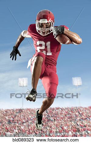Stock Image - African American football player running with football. Fotosearch