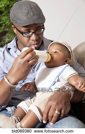 African American man feeding baby son bottle View Large Photo Image Stock Image - African American man feeding baby son bottle. Fotosearch