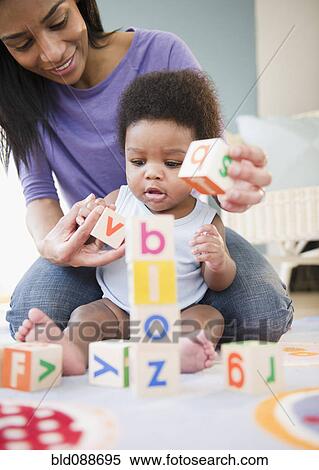 Stock Photography - African American mother and son playing with alphabet blocks. Fotosearch