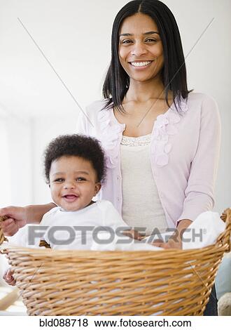Stock Photo - African American mother carrying baby boy in basket. Fotosearch