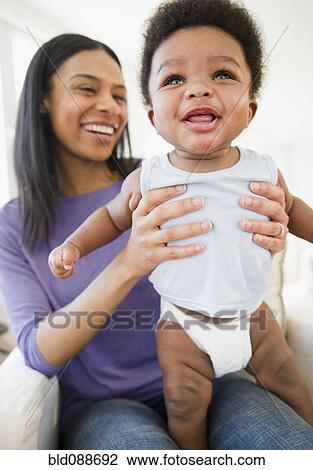 Stock Image - African American mother holding baby boy. Fotosearch