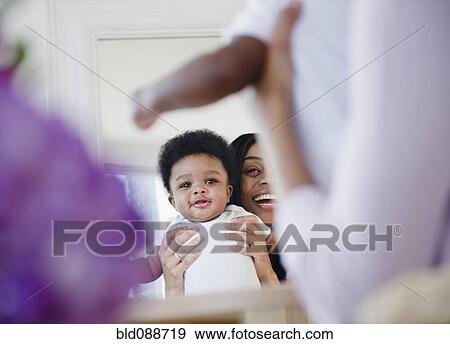 African American mother holding son up in mirror View Large Photo Image Stock Photo - African American mother holding son up in mirror. Fotosearch