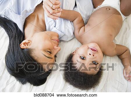 African American mother laying with baby boy View Large Photo Image Picture - African American mother laying with baby boy. Fotosearch