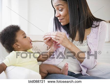 Stock Image - African American mother playing with baby boy. Fotosearch