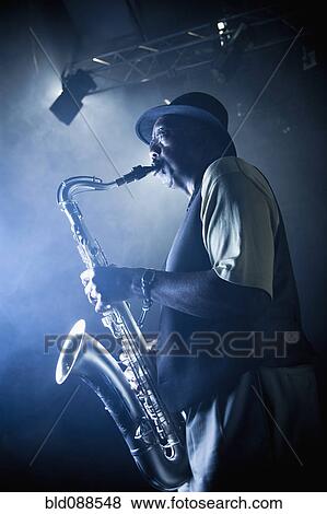 Stock Photo - African American musician playing saxophone on stage. Fotosearch