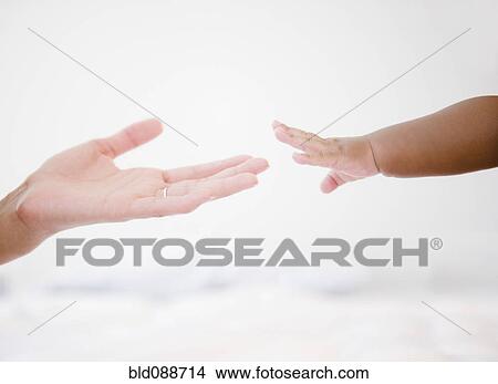 Picture - African American woman reaching out to baby boy. Fotosearch