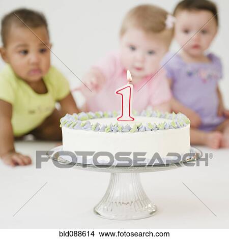 Picture - Babies looking at first birthday cake. Fotosearch