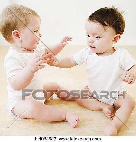 Stock Photo - Babies playing on floor. Fotosearch
