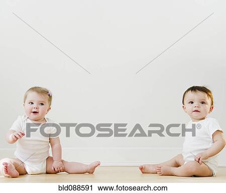 Stock Image - Babies sitting on floor. Fotosearch