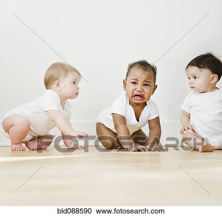 Stock Image - Babies watching crying friend. Fotosearch