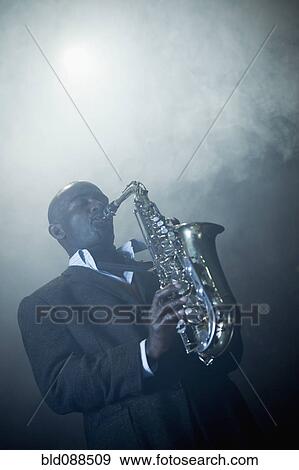 Black musician playing saxophone on stage View Large Photo Image Stock Photo - Black musician playing saxophone on stage. Fotosearch