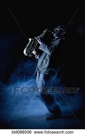 Black musician playing saxophone on stage View Large Photo Image Stock Photograph - Black musician playing saxophone on stage. Fotosearch